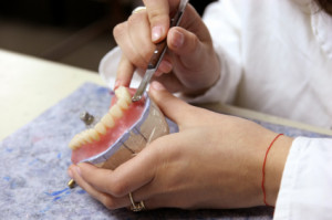 A dentist fixing dentures
