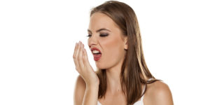 Woman smelling her bad breath
