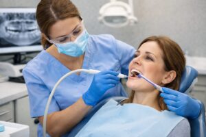 Dental hygienist performing a professional teeth cleaning for a patient in Franklin Square Long Island NY